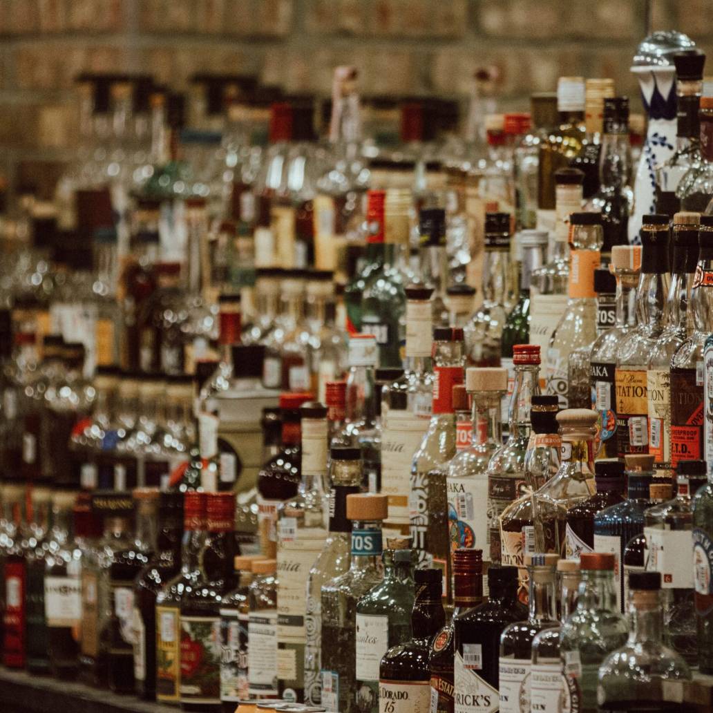 clear glass bottles on brown wooden shelf